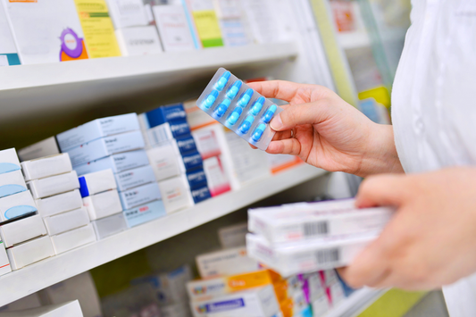 A pharmacist holding a blister pack of antibiotics accompanying a blog post on how Can Antibiotics Cause Constipation?